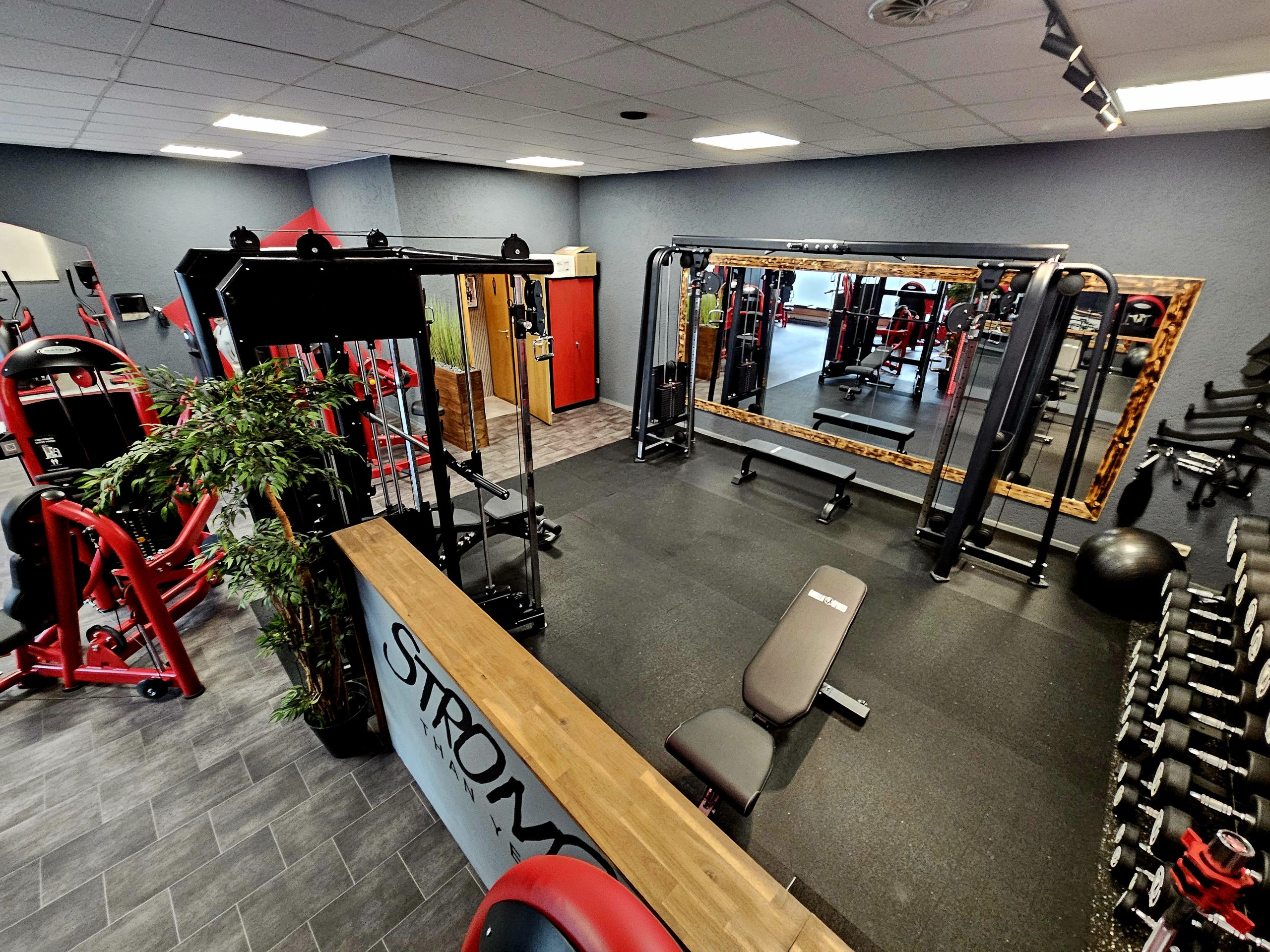 Freihantelbereich im TWENTY FOUR SEVEN fit in Beuna, Merseburg Freihantelbereich mit großen Spiegeln und Kabelzugstation im Fitnessstudio TWENTY FOUR SEVEN fit in Beuna, Merseburg.